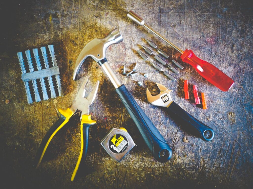 pexels-photo-175039 Collection of hand tools including hammer, screwdriver, and pliers in a workshop setting.